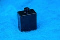 A small black glass open bottle stands on blue wool Royalty Free Stock Photo