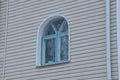 A small blue window on a gray plastic wall of a building Royalty Free Stock Photo