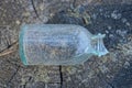 one small dirty white glass old bottle with a broken neck