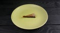 One small fish of sprats in a ceramic plate on a black wooden table closeup Royalty Free Stock Photo