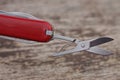 One small gray metal scissors on a red multitool Royalty Free Stock Photo