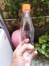 One small half liter clear plastic water bottle, holding bottle, reduce plastic usage, plastic bottle on front view