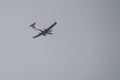 One  small modern propeller plane flies in the gray sky Royalty Free Stock Photo