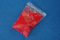 One small plastic bag with red sand