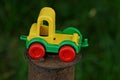 One small plastic colored toy car stands on a brown rusty iron pole Royalty Free Stock Photo