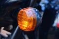 one small round red glass headlight turn signal on a black motorcycle Royalty Free Stock Photo