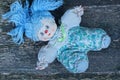 One small white cloth doll with blue hair