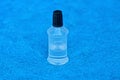 A small white plastic bottle with a black cork with a liquid on a blue wool background Royalty Free Stock Photo