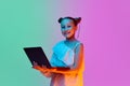 One smart, schoolage little girl, child posing with laptop against gradient pink-blue background. Online education