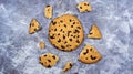 One soft freshly baked chocolate chip cookie with crumbs and chunks on a gray marble kitchen countertop. American traditional