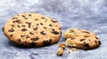 One soft, freshly baked chocolate chip cookie on a gray marble kitchen countertop. American traditional dessert. Delicious sweet