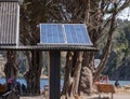 One solar panel in a pole in the middle of a park with a lake and trees around it Royalty Free Stock Photo