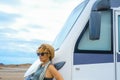 One solo alone woman traveler look outside her modern big camper van motorhome. Concept of living adventure. Nomadic travel