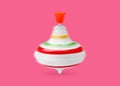 One spinning top in motion on pink background. Toy whirligig