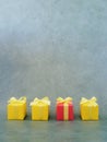 Four square red and yellow gift boxes neatly placed on green textured background, vertical. Royalty Free Stock Photo