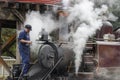 One staff is cleaning the ash from smokebox of the steam Locomotive