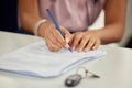 One step closer to owning my first car. a young woman signing paperwork.