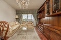 One-story living room with wooden furniture, a matching table, a wall with a mural of the same tone