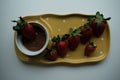 Strawberry dipped in milk chocolate on vintage polka dot yellow tray