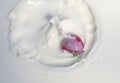 One strawberry splashing into creamy yogurt Royalty Free Stock Photo