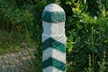 One striped concerte signal pole among the green vegetation Royalty Free Stock Photo