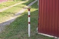 One striped iron pipe boundary post Royalty Free Stock Photo