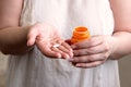 One tablet on one palm and orange pill bottle in another Royalty Free Stock Photo