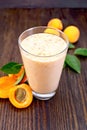 Milkshake apricot in high glassful on board Royalty Free Stock Photo