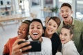 One of the team. a diverse group of businesspeople standing together and taking a selfie with a cellphone in the office. Royalty Free Stock Photo