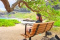 One teen girl sitting on bench at Makapu`u beach park