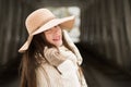 One teenage high school senior portrait wearing floppy hat at covered bridge in winter