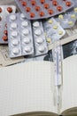 One thermometer on the notepad with some pills Royalty Free Stock Photo