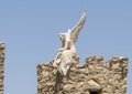 One of three archangel statues atop a stone building, part of the Monastery of Saint Simon.