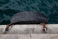 Single Old Tire Hanging By Rusty Chains In Shipyard