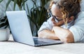 One tired and bored woman in front of a laptop in home office workplace. Online business job. Adult female asleep against a Royalty Free Stock Photo