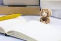 One tired toy monkey with notepad and pencil and many thick books Royalty Free Stock Photo