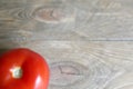 One tomato red, natural close-up isolated on a wooden brown background. Royalty Free Stock Photo