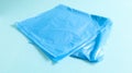 One torn plastic garbage bag in blue on a blue background. A bag that is designed to accommodate garbage in it and is used at home Royalty Free Stock Photo