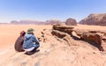 One tourist with his local guide looking at the stone arch in the desert of wadi rum in Jordan. Blue sky Royalty Free Stock Photo