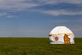 Russia. One traditional Kalmyk or Mongol yurts in a green spring steppe under the blue sky