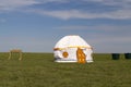 Russia. One traditional Kalmyk or Mongol yurts with washbasins and garbage cans in a green spring steppe under the blue sky