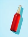 One transparent glass bottle with metal cap laying on light blue surface Royalty Free Stock Photo