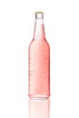 One transparent glass bottle. Pink drink in bottle with condensed water drops isolated on white