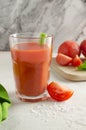 One transparent glass cup with red tomato juice and a sprig of celery on a light background. Healthy food concept. Royalty Free Stock Photo