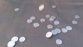 One and Two Rupees Indian Coins Dropping On Black Paper Floor in Slow Motion