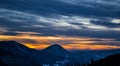 One very interesting sunset. View from above on the hills in the distance. The blue and yellow color of the sky in the background. Royalty Free Stock Photo