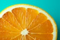 One vibrant orange slice on a turquoise green background, a zesty citrus texture