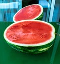 One watermelon cuted in halves on green glass table