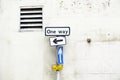 One way directional arrow sign against white wall background Royalty Free Stock Photo