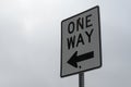 One way sign under a cloudy sky